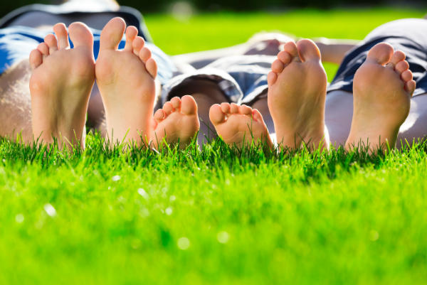 Fertilizing Services & Weed Control Services | Family laying in the yard facing their feet towards the camera.